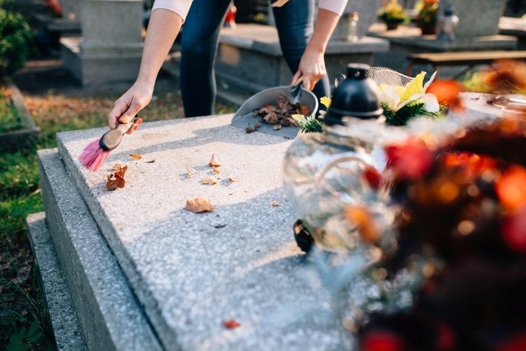 personne qui nettoie un monument funeraire
